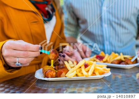 Couple eating German Currywurst at stand Couple eating German Currywurst at stand 14010897