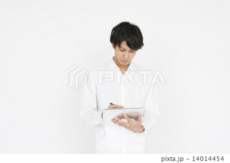 何かを記入する白いシャツの若い男性 14014454