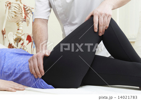 Male Osteopath Treating Female Patient With Hip Problem 14021783
