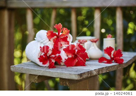 Spa setting with towels and red flowers Spa setting with towels and red flowers 14024061