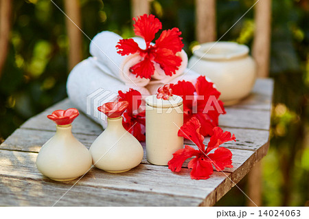 Spa setting with towels and red flowers 14024063