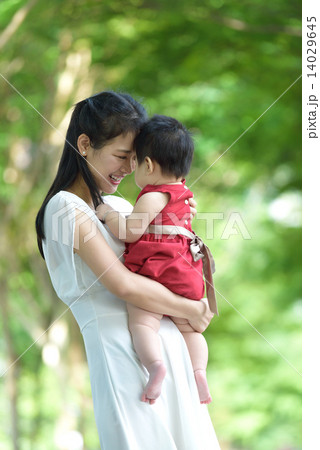 Chinese mother carrying baby in a park Chinese mother carrying baby in a park 14029645