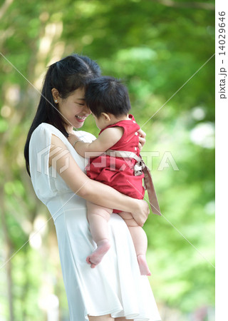 Chinese mother carrying baby in a park 14029646
