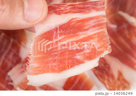 Top view of caucasian man hand taking Serrano ham slice 14036249