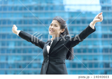 Successful chinese businesswoman celebrating arms in front of blue glass office building Successful chinese businesswoman celebrating arms in front of blue glass office building 14040603