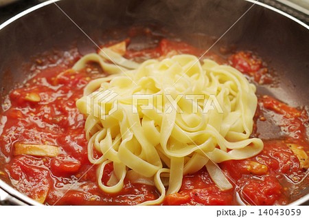 炒めたトマトソースにパスタを 炒めたトマトソースにパスタを 14043059
