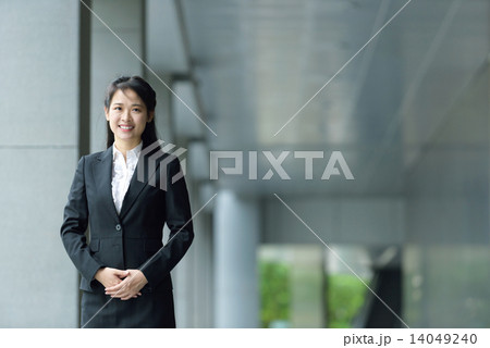 Successful chinese businesswoman along office building walkway Successful chinese businesswoman along office building walkway 14049240