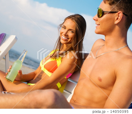 Young couple relaxing on a deck chairs on a beach 14050395