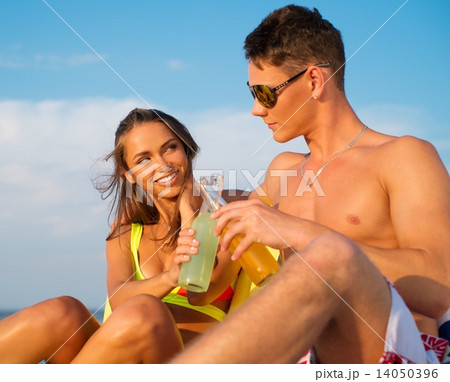 Young couple relaxing on a deck chairs on a beach Young couple relaxing on a deck chairs on a beach 14050396