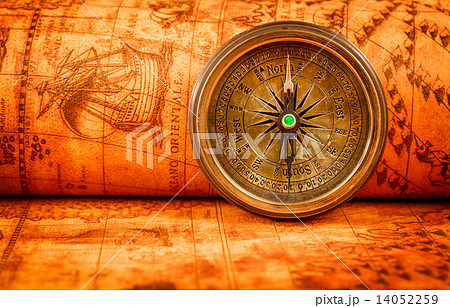 Vintage compass lies on an ancient world map. 14052259