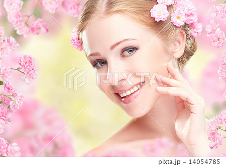 Beauty face of young happy beautiful woman with pink flowers in 14054785