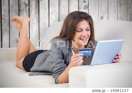Composite image of woman doing online shopping with tablet and c Composite image of woman doing online shopping with tablet and c 14061157