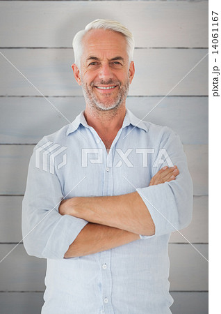 Composite image of smiling man posing with arms crossed 14061167