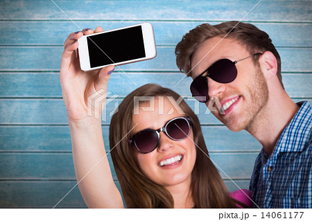 Composite image of couple taking selfie with smart phone Composite image of couple taking selfie with smart phone 14061177