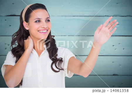 Composite image of pretty brunette holding out hand 14061358
