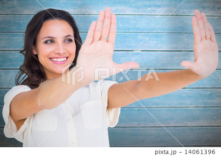 Composite image of pretty brunette holding up hands Composite image of pretty brunette holding up hands 14061396