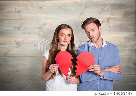Composite image of couple holding broken heart Composite image of couple holding broken heart 14061447