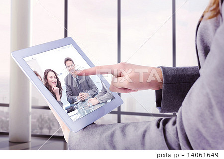 Composite image of businesswoman using a tablet pc Composite image of businesswoman using a tablet pc 14061649