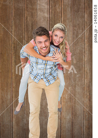 Composite image of handsome man giving piggy back to his girlfri Composite image of handsome man giving piggy back to his girlfri 14061658