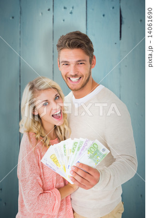 Composite image of attractive couple flashing their cash Composite image of attractive couple flashing their cash 14061690