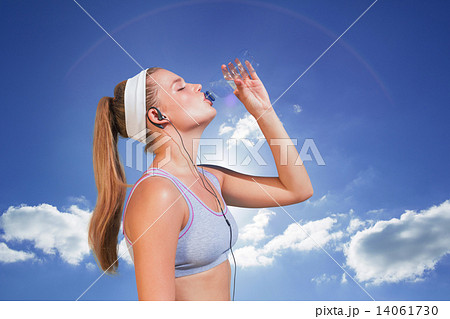 Composite image of sporty blonde drinking water 14061730