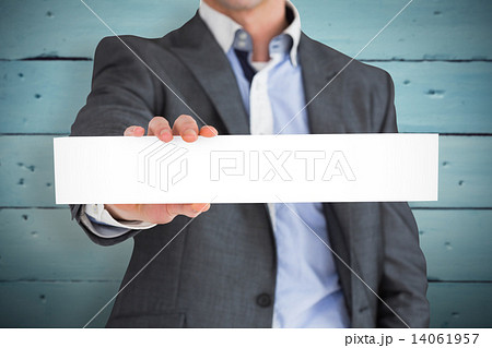 Composite image of businessman in grey suit showing card 14061957