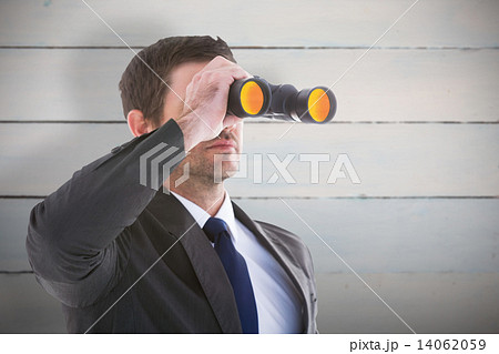 Composite image of young businessman looking through binoculars Composite image of young businessman looking through binoculars 14062059