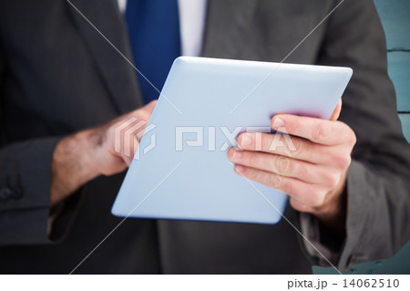 Composite image of businessman scrolling on his digital tablet Composite image of businessman scrolling on his digital tablet 14062510
