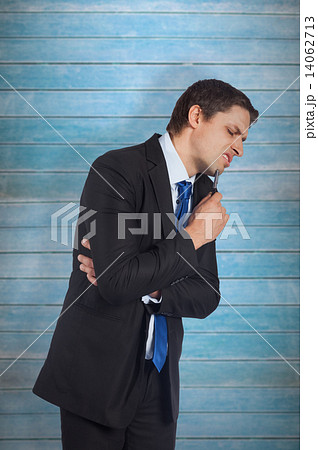 Composite image of thinking businessman holding pen 14062713