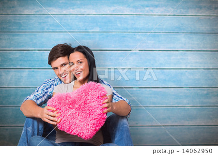 Composite image of young couple sitting on floor smiling Composite image of young couple sitting on floor smiling 14062950