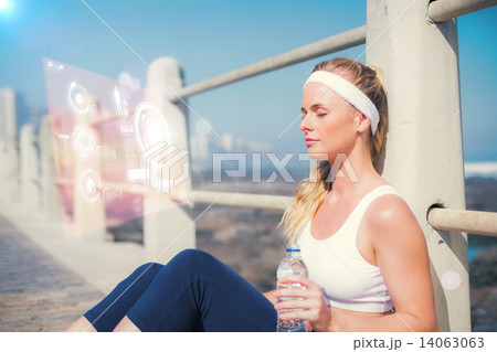 Composite image of fit blonde sitting on the pier 14063063
