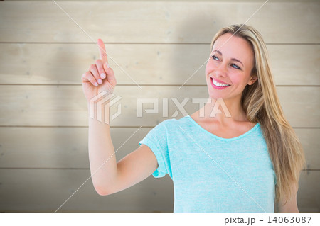 Composite image of portrait of smiling blonde pointing up Composite image of portrait of smiling blonde pointing up 14063087