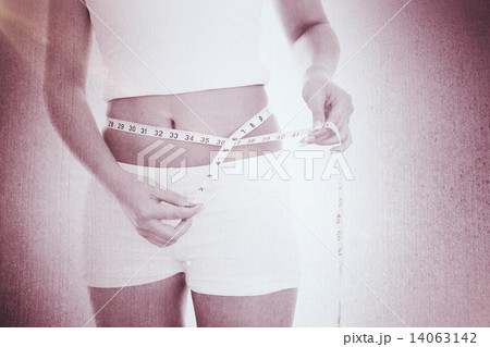 Composite image of midsection of woman measuring waist Composite image of midsection of woman measuring waist 14063142