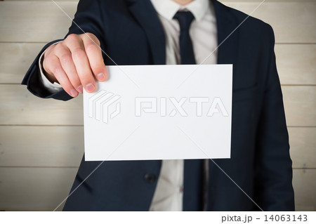 Composite image of businessman showing card to camera Composite image of businessman showing card to camera 14063143