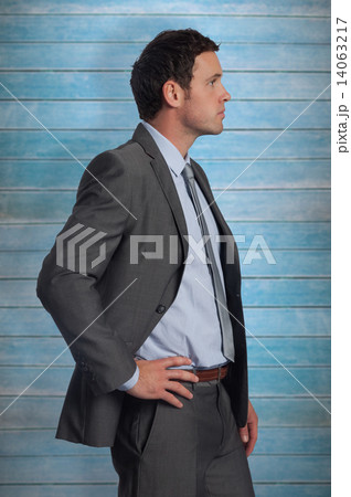 Composite image of serious businessman with hand on hip Composite image of serious businessman with hand on hip 14063217
