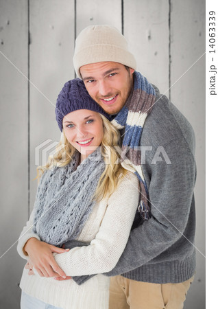 Composite image of attractive couple in winter fashion hugging Composite image of attractive couple in winter fashion hugging 14063339