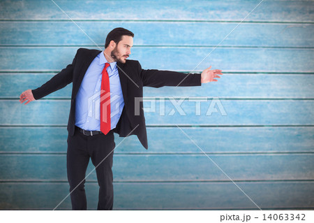 Composite image of serious businessman in suit gesturing with ha 14063342