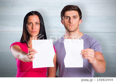 Composite image of couple showing broken piece of paper Composite image of couple showing broken piece of paper 14063444