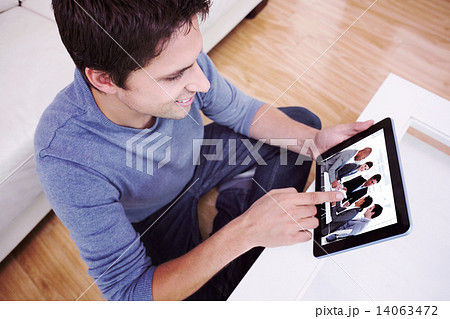 Composite image of overhead view of man using digital tablet in Composite image of overhead view of man using digital tablet in 14063472