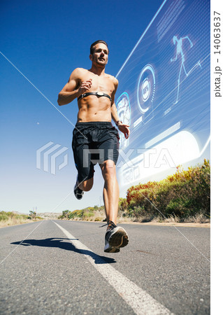 Composite image of athletic man jogging on open road with monito Composite image of athletic man jogging on open road with monito 14063637