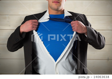 Composite image of businessman opening his shirt superhero style 14063638