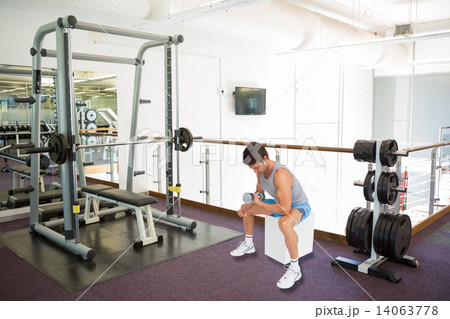 Composite image of side view of a fit man exercising with dumbbe Composite image of side view of a fit man exercising with dumbbe 14063778