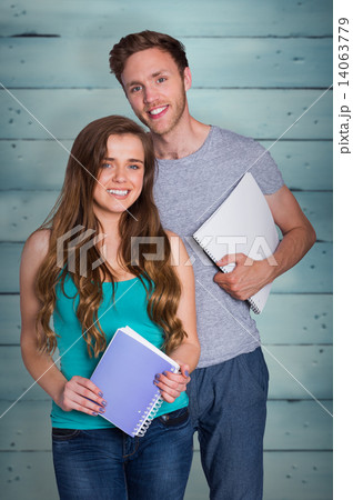 Composite image of portrait of smiling young couple with books Composite image of portrait of smiling young couple with books 14063779