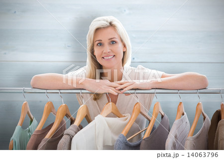 Composite image of pretty blonde smiling at camera by clothes ra Composite image of pretty blonde smiling at camera by clothes ra 14063796