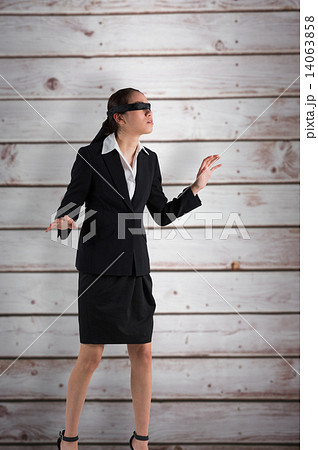Composite image of blindfolded businesswoman with hands out Composite image of blindfolded businesswoman with hands out 14063858