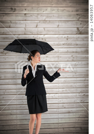 Composite image of young businesswoman holding umbrella Composite image of young businesswoman holding umbrella 14063957