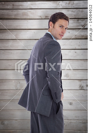 Composite image of serious businessman with hands on hips Composite image of serious businessman with hands on hips 14064012