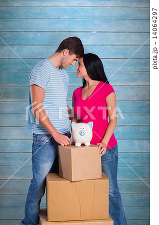 Composite image of young couple with moving boxes Composite image of young couple with moving boxes 14064297