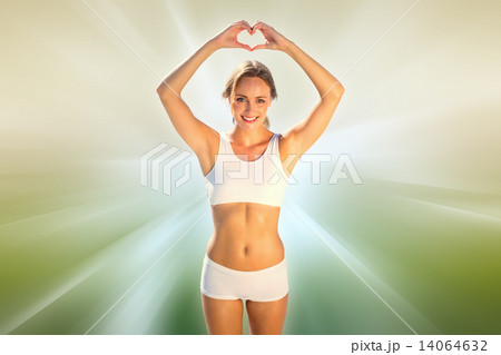 Composite image of gorgeous fit blonde making heart shape with h Composite image of gorgeous fit blonde making heart shape with h 14064632