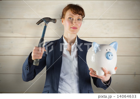 Composite image of businesswoman breaking piggy bank Composite image of businesswoman breaking piggy bank 14064633